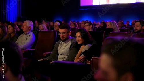  Couple watching a film in crowded movie theatre 