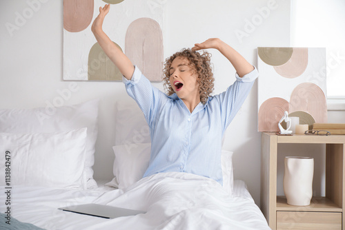 Awake young woman with lapt...