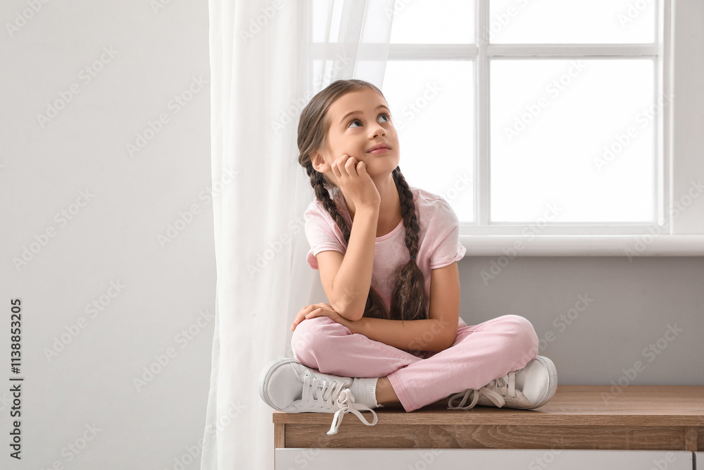 Thoughtful little girl sitting on commode at home Thoughtful little girl sitting on commode at home