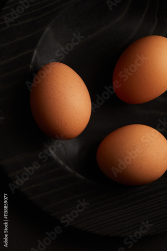 Chicken eggs on black background. View from the top