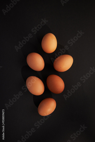 Chicken eggs on black background. View from the top