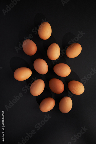 Chicken eggs on black background. View from the top