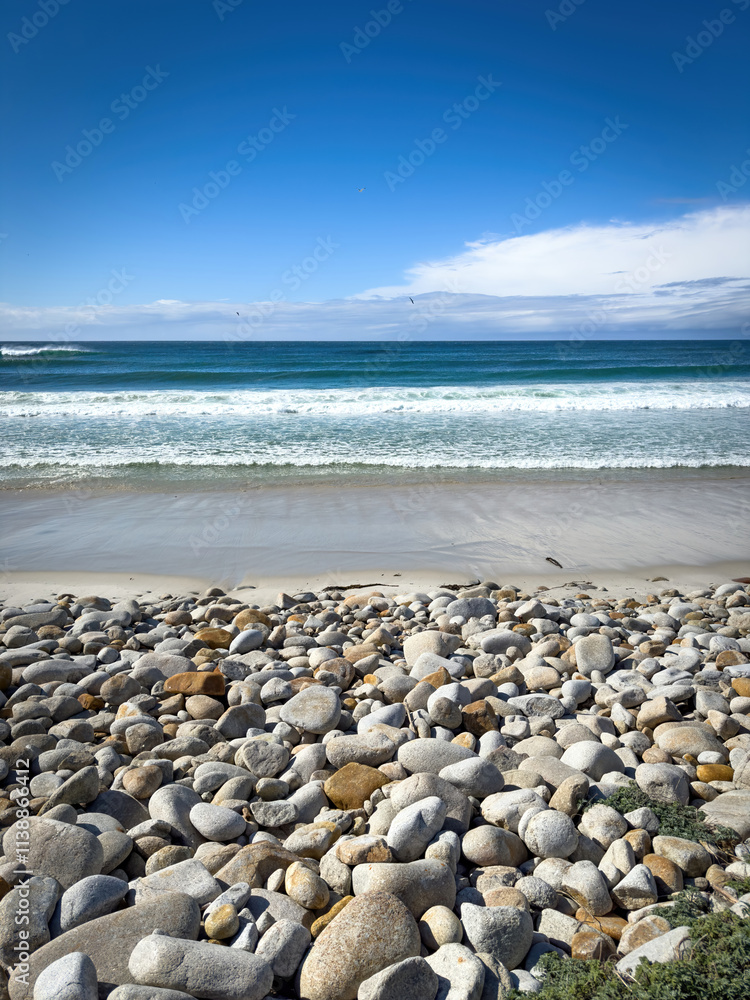 Scenic view of Moss Beach with big round stones along 17-Mile-Drive, Del Monte Forest, California, USA against blue sky with clouds