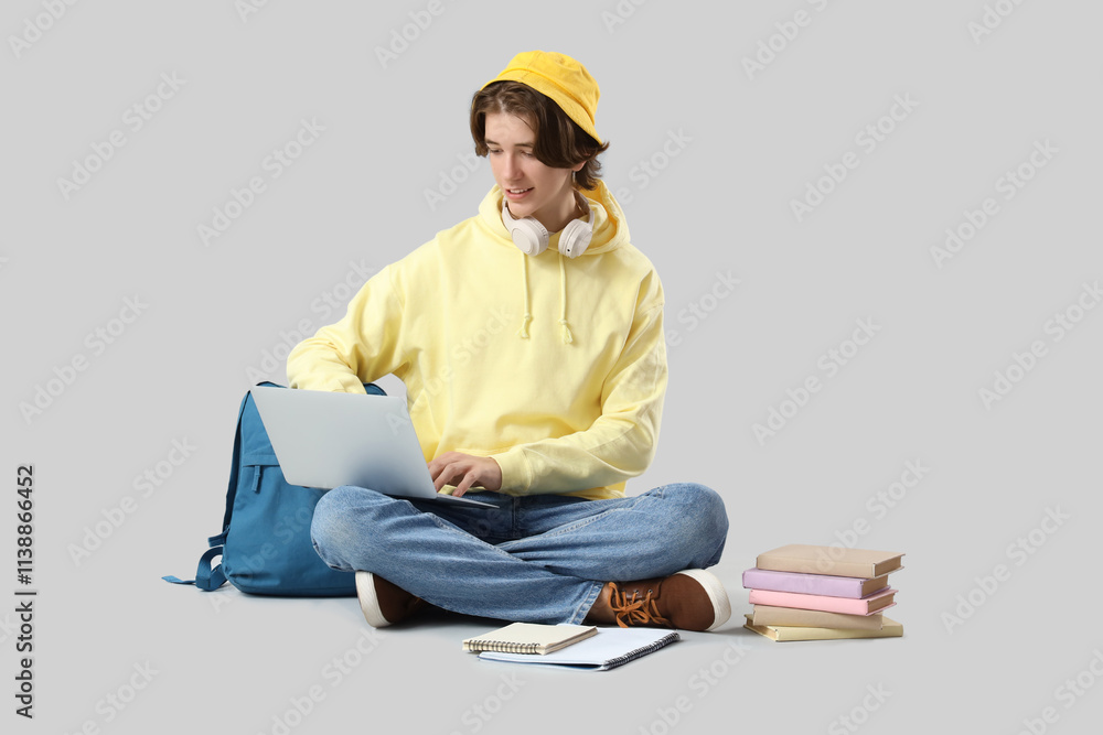 Male student studying with laptop on light background Male student studying with laptop on light background