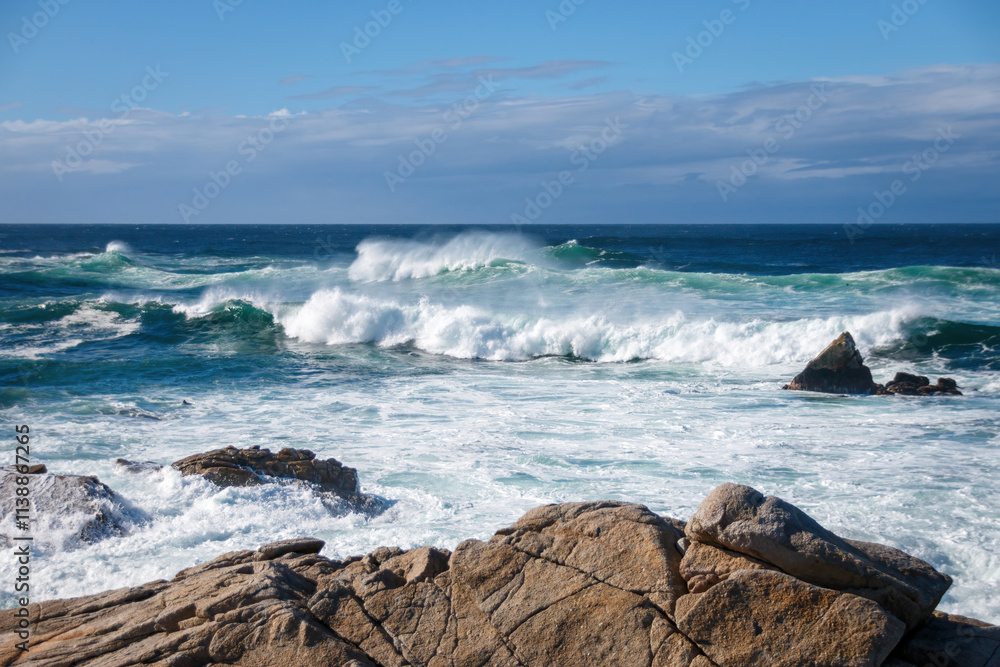 Scenic view of Pacific Ocean waves at the coast seen from Spanish Bay Vista Point, Del Monte Forest, California, USA against blue sky with clouds