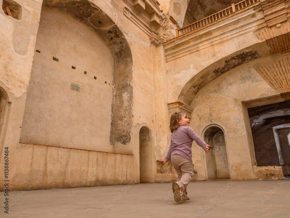 Beautiful Latina girl explores the architecture of a colonial church with her mother supervising her. Beautiful Latina girl explores the architecture of a colonial church with her mother supervising her.