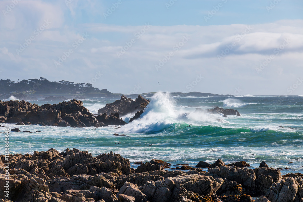 Scenic view rocky Pacific Ocean coast along 17-Mile-Drive looking south, Del Monte Forest, California, USA against blue sky with clouds