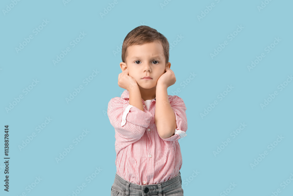 Little boy suffering from ear pain on blue background Little boy suffering from ear pain on blue background
