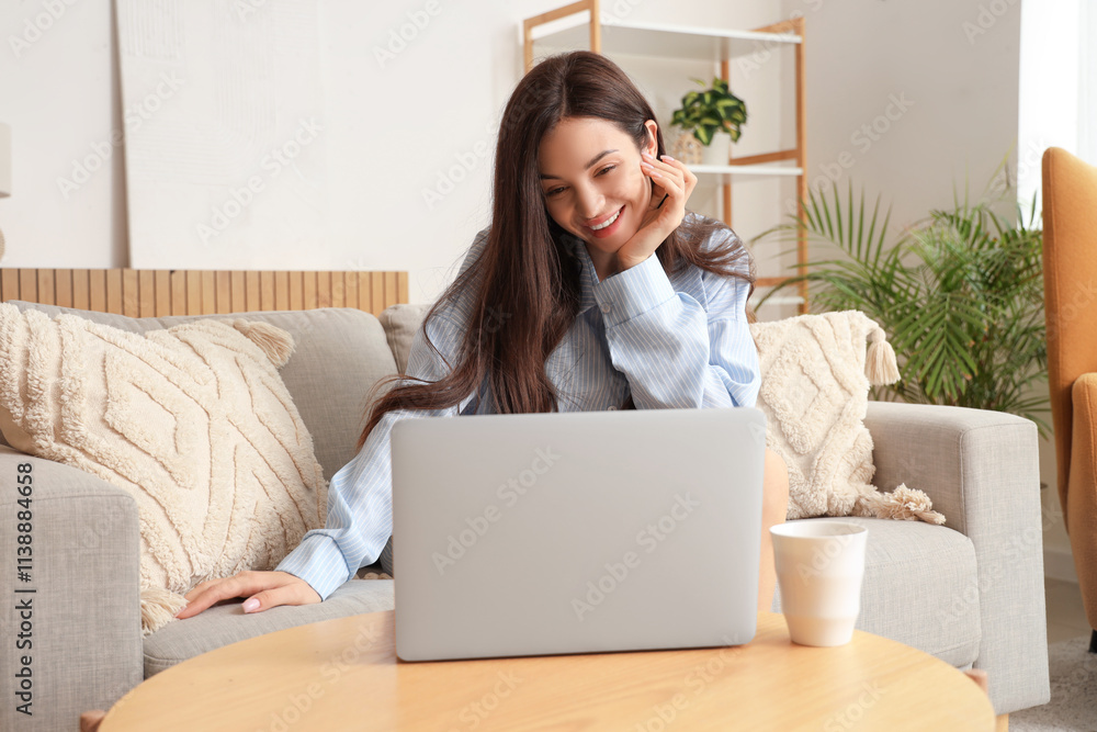Young woman in blue pajamas working with laptop at home Young woman in blue pajamas working with laptop at home