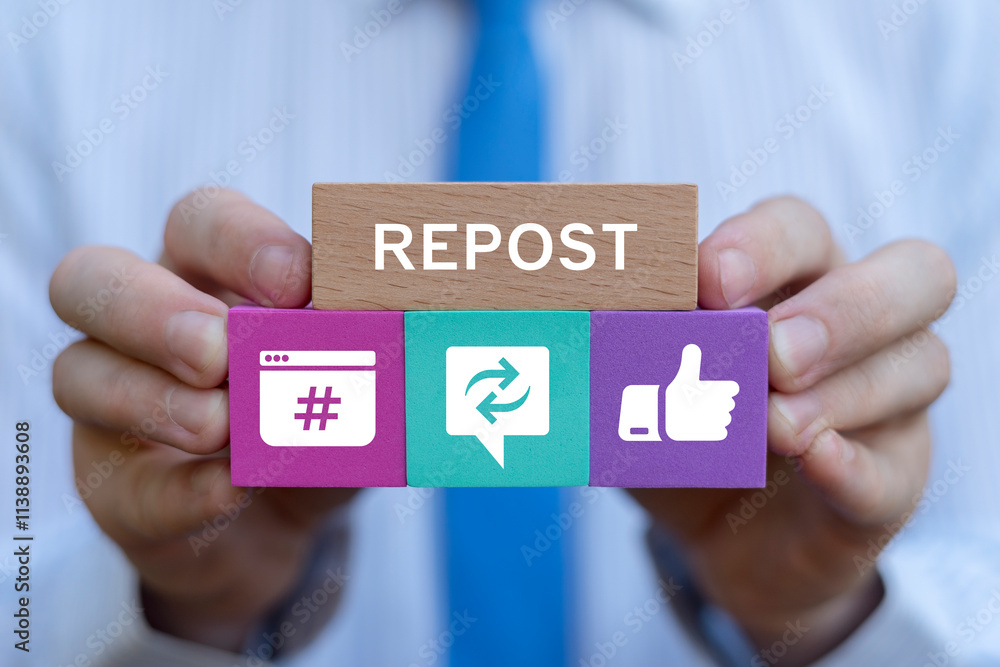 Businessman holding colorful blocks with icons sees text: REPOST. Repost sharing viral content online concept. Repost social media web information technology.