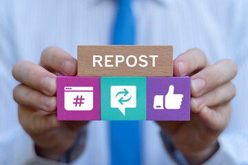 Businessman holding colorful blocks with icons sees text: REPOST. Repost sharing viral content online concept. Repost social media web information technology.