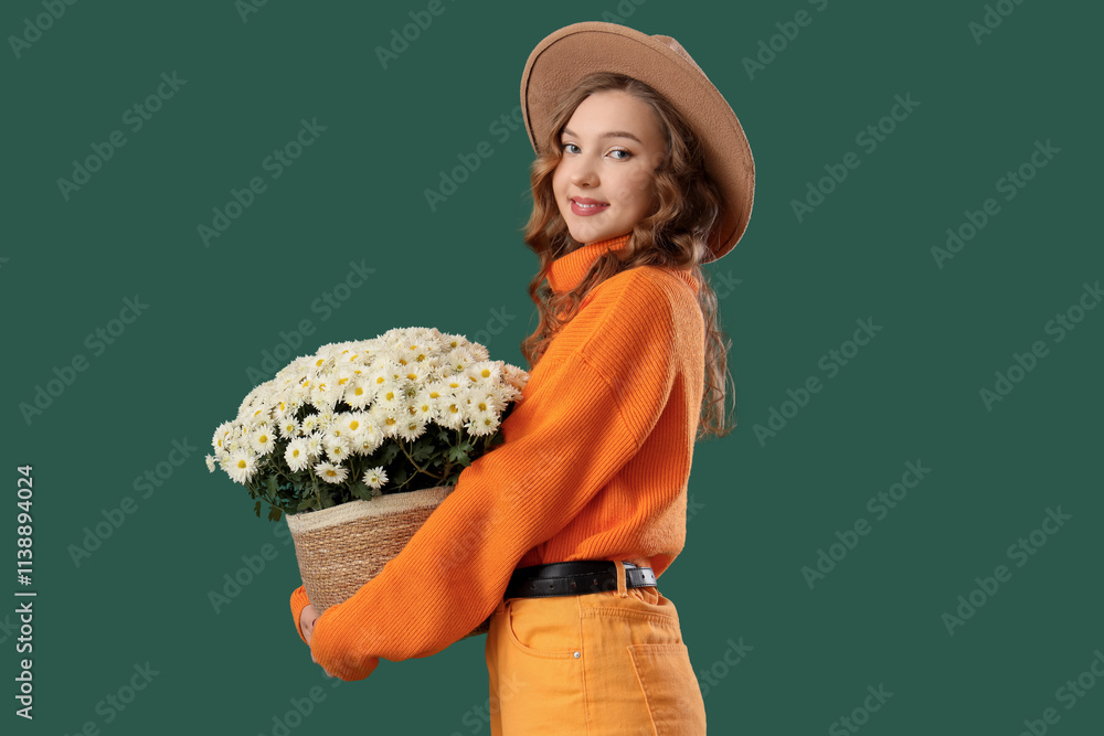 Fashionable young woman with beautiful chrysanthemum flowers on green background Fashionable young woman with beautiful chrysanthemum flowers on green background