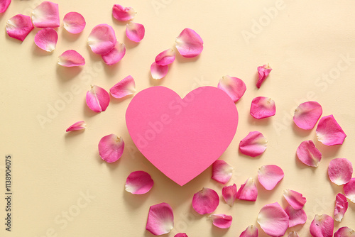 Blank card in shape of heart with beautiful rose petals on beige background