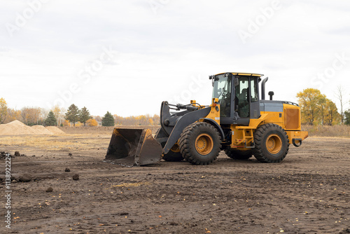 Front loader at work site. Wheel loader moving dirt