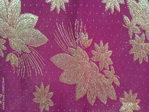 The texture of the fabric is red with a pattern of gold.Songket or sungkit is a tenun fabric  of malaysia, indonesia and brunei