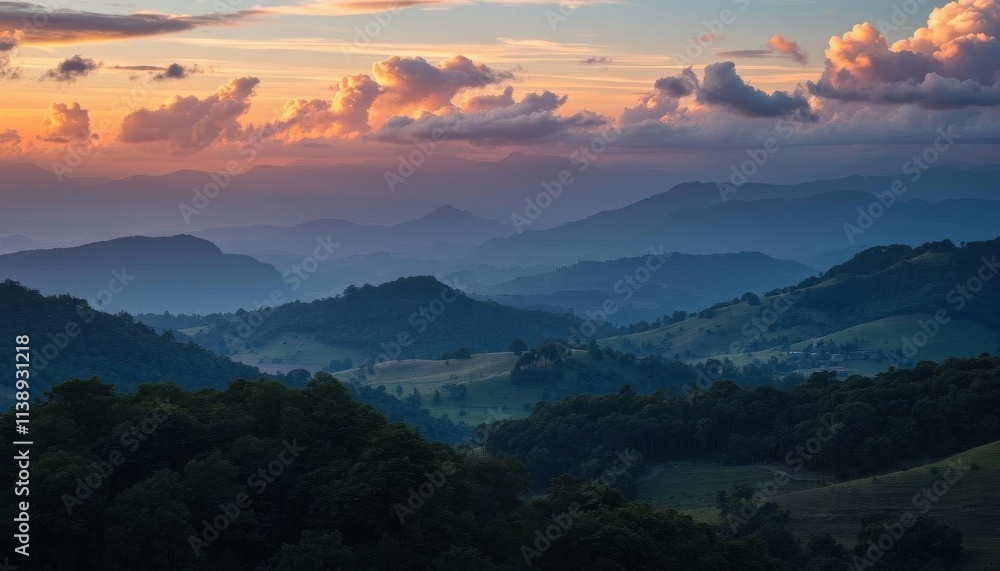 a view of a valley with mountains and trees at sunset