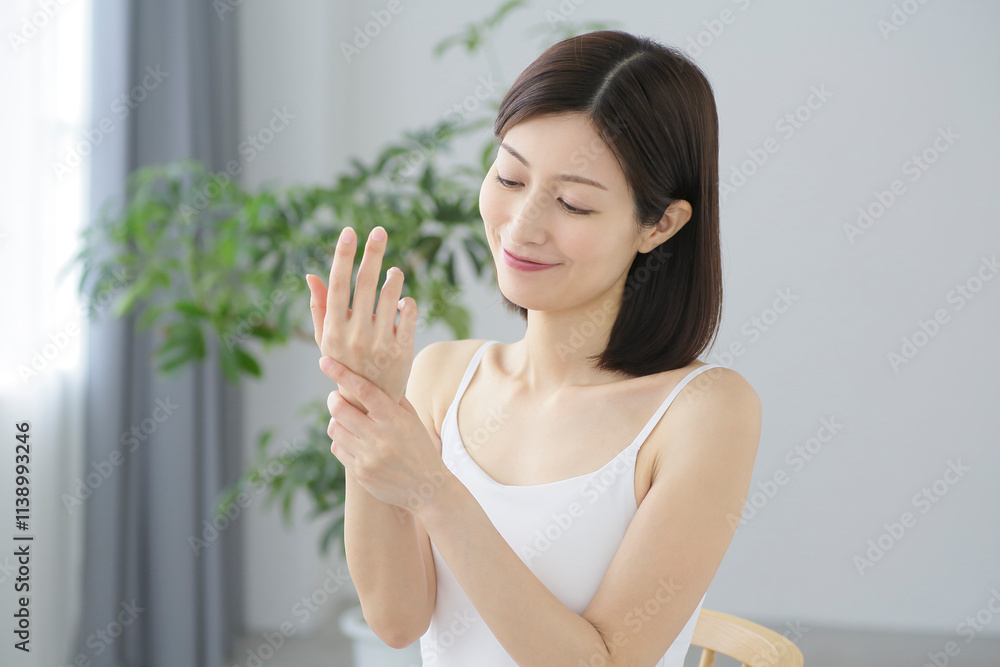 腕をマッサージする女性