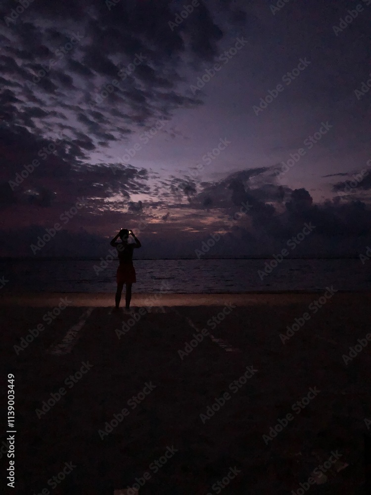 Obraz premium Man watching sunrise at the beach