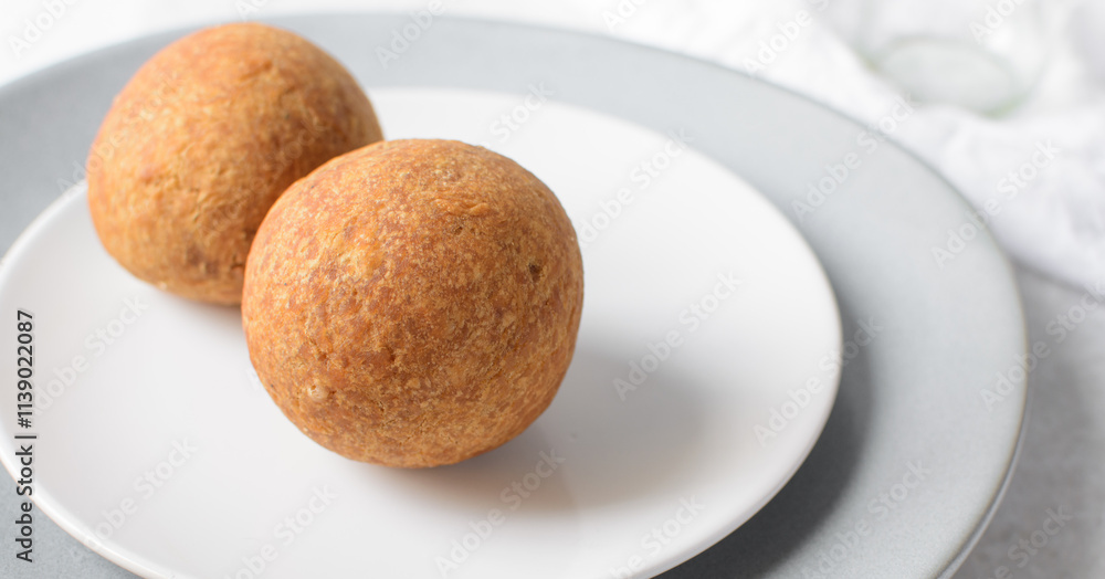 homemade nigerian egg roll in a white ceramic plate, freshly made african egg roll on a white plate, egg wrapped in fried dough homemade nigerian egg roll in a white ceramic plate, freshly made african egg roll on a white plate, egg wrapped in fried dough