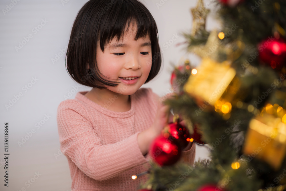 クリスマスツリーを飾りつける女の子 クリスマスツリーを飾りつける女の子
