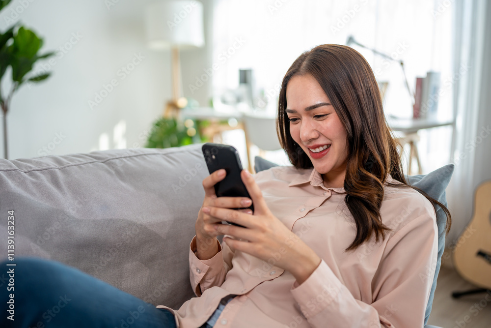 Asian beautiful woman sitting on sofa and swipe mobile phone in house. Asian beautiful woman sitting on sofa and swipe mobile phone in house.