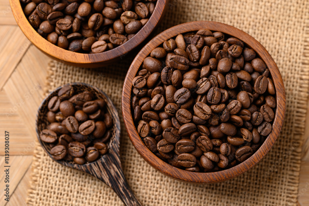 Fototapeta premium Roasted coffee beans in wooden bowl with spoon, Arabica coffee, Top view