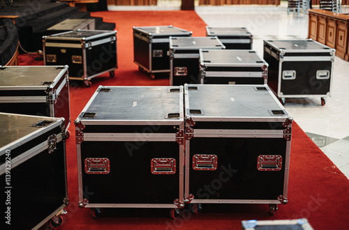 Canvastavla Stacked black flight cases in a large room preparing to set up for concert or la