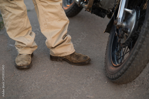 a biker near a motorcycle. biker boots photo