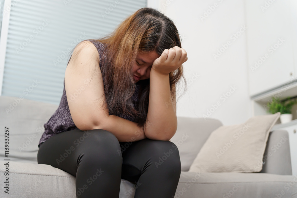 Sad Overweight plus size woman thinking about problems on sofa upset girl feeling lonely and sad from bad relationship or Depressed woman disorder mental health Sad Overweight plus size woman thinking about problems on sofa upset girl feeling lonely and sad from bad relationship or Depressed woman disorder mental health