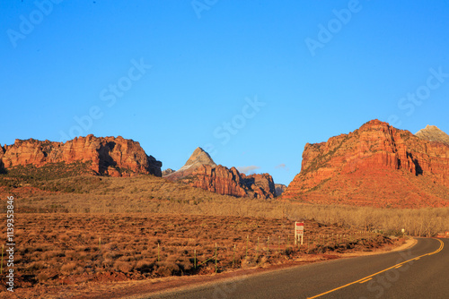 A road in the desert with a sign on the side