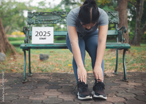 A woman doing morning exercises and holding a calendar next to her. Concept of the beginning of 2025. A new beginning for the coming new year. photo