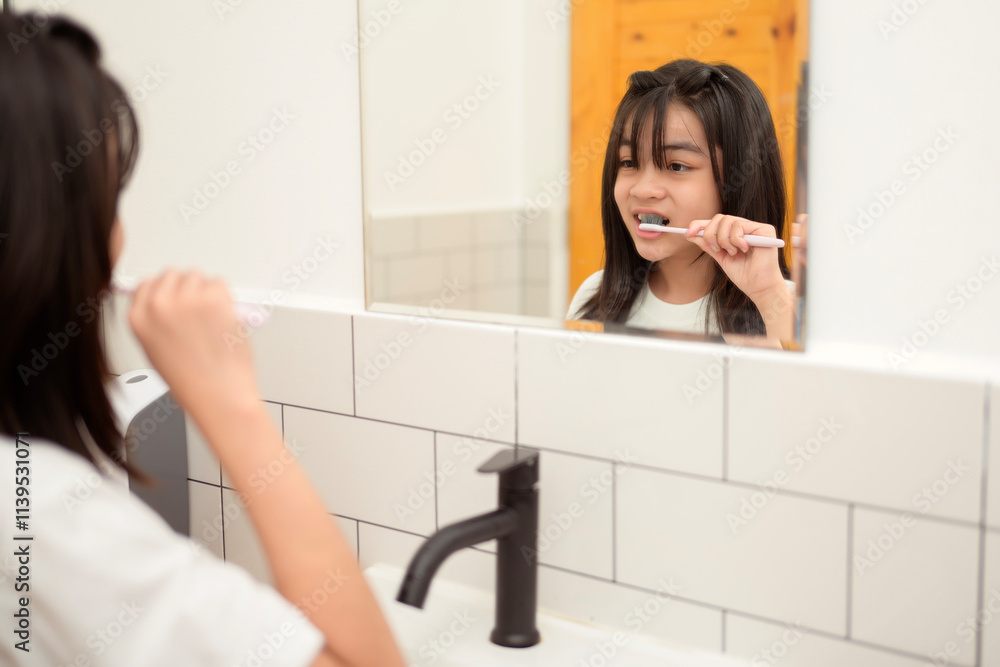 A young woman brushing her teeth in restroom A young woman brushing her teeth in restroom