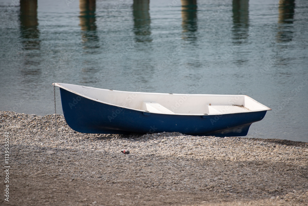 A small blue boat is sitting on the beach A small blue boat is sitting on the beach