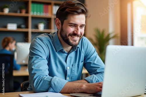 Happy Man Working on Laptop in Modern Office Space, Ideal for Business and Technology Websites