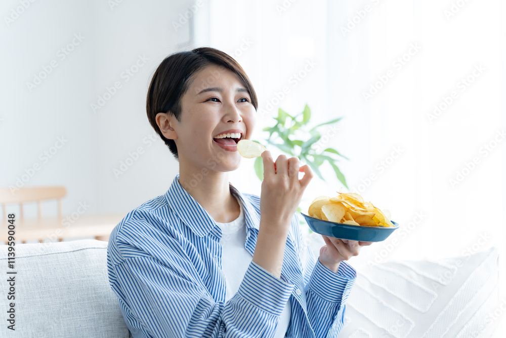 家でポテトチップを食べる女性 家でポテトチップを食べる女性