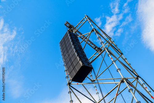 Overhead stage rigging equipment  Concert stage with outdoor lighting and sound equipment on cloudy sky background and afternoon sun with copy space