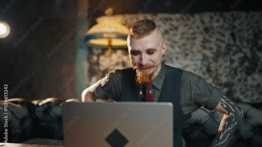 Portrait of adult man with extravagant beard and moustache working with PC. Male internet user browsing web-sites, communicating in social networks, working remotely, typing text and sending messages