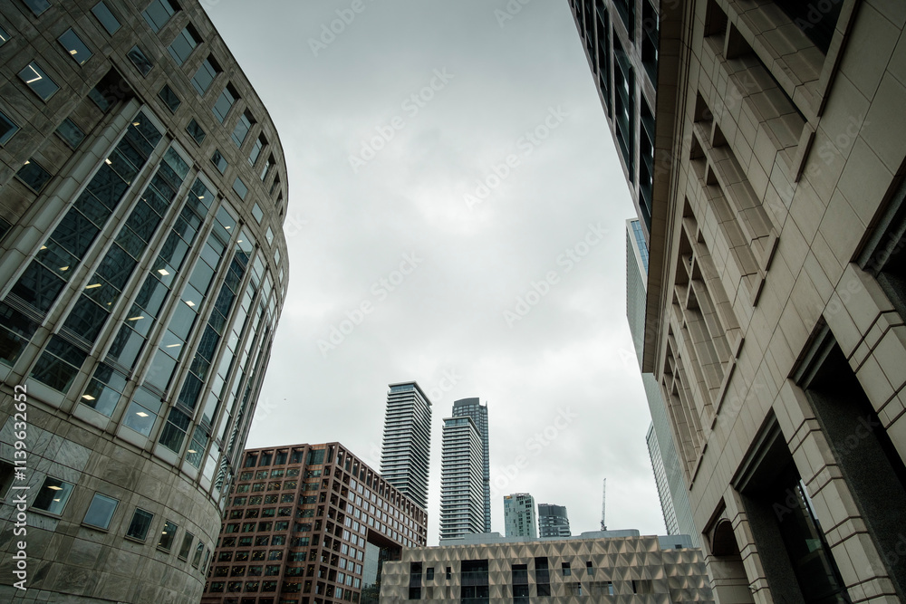 Modern skyscrapers reaching for the cloudy sky in canary wharf, london Modern skyscrapers reaching for the cloudy sky in canary wharf, london