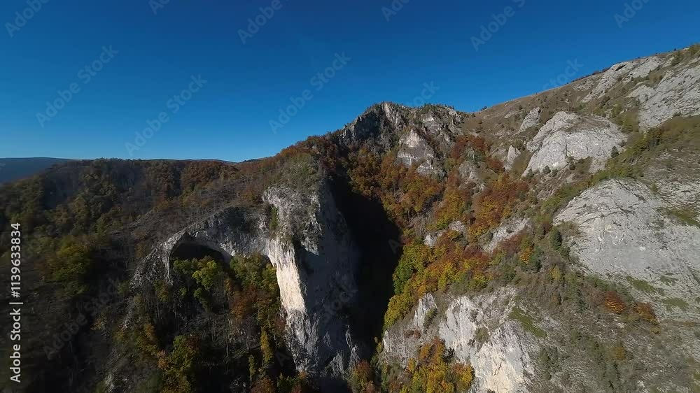 The cliffs of Scarita Belioara, surrounded by vibrant autumn colors and rocky terrain, create a picturesque hiking destination in Transylvania, Romania. The cliffs of Scarita Belioara, surrounded by vibrant autumn colors and rocky terrain, create a picturesque hiking destination in Transylvania, Romania.