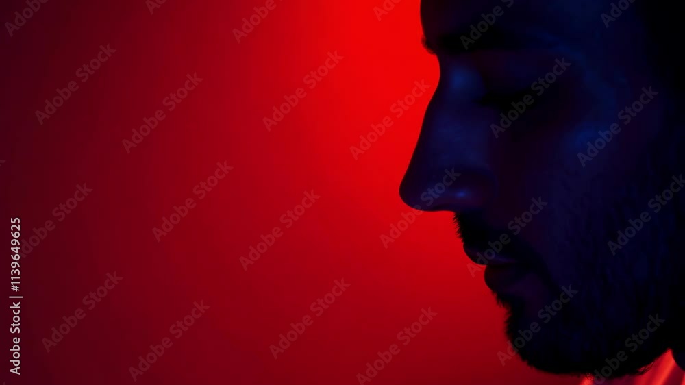 Dramatic silhouette of a man under intense red lighting with subtle movement Dramatic silhouette of a man under intense red lighting with subtle movement