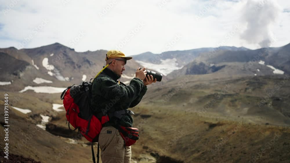 Man In Mountains, Traveler With Photo Camera Taking Pictures Of Fascinating Scenery In Highlands Man In Mountains, Traveler With Photo Camera Taking Pictures Of Fascinating Scenery In Highlands