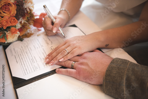 A bride and groom signing the wedding register