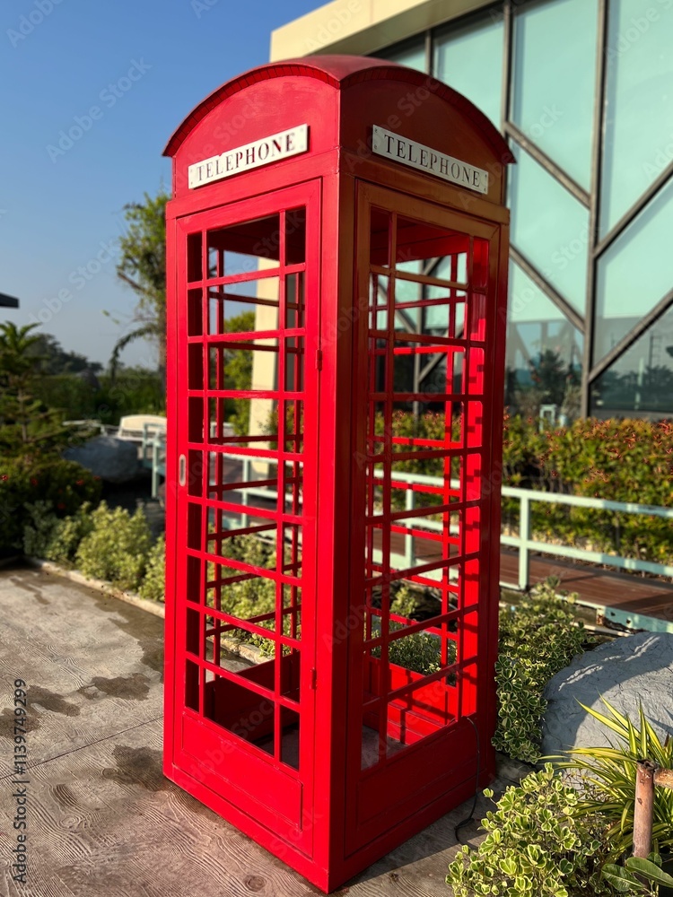 Classic red telephone booth in garden setting. Classic red telephone booth in garden setting.