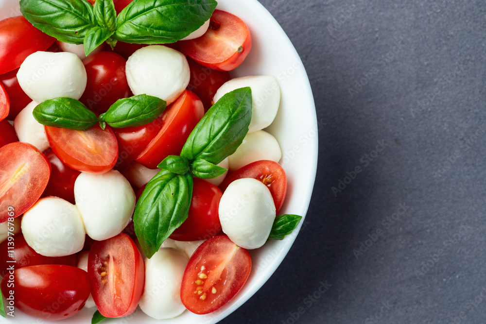 Basil leaves , cherry tomatoes and mozzarella cheese . In bowl food photography Basil leaves , cherry tomatoes and mozzarella cheese . In bowl food photography