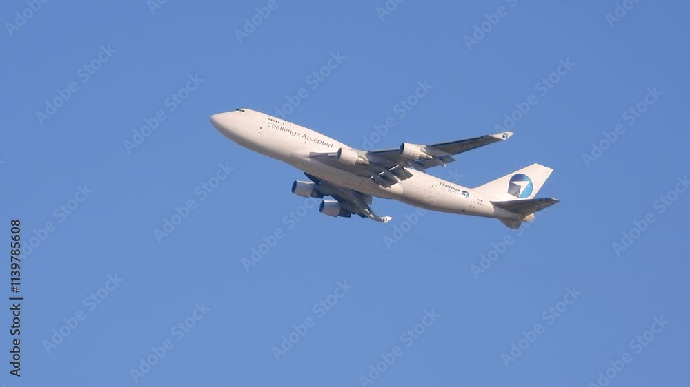 Large commercial airplane ascending against a clear blue sky in daylight captured from below Large commercial airplane ascending against a clear blue sky in daylight captured from below