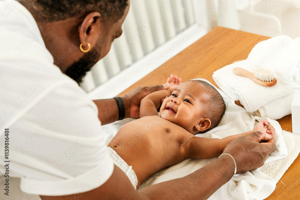 A joyful father interacts with his smiling baby during a tender moment on a changing table, fostering connection and playfulness. Happy diversity family and newborn bathing concept. A joyful father interacts with his smiling baby during a tender moment on a changing table, fostering connection and playfulness. Happy diversity family and newborn bathing concept.