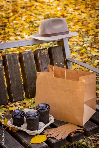 Autumn Scene with a Park, Bench, Coffee, Paper Bag, and a Hat