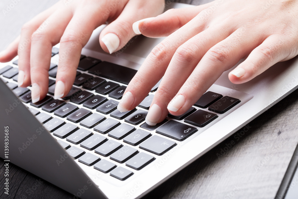 Young woman entering data on a laptop computer Young woman entering data on a laptop computer