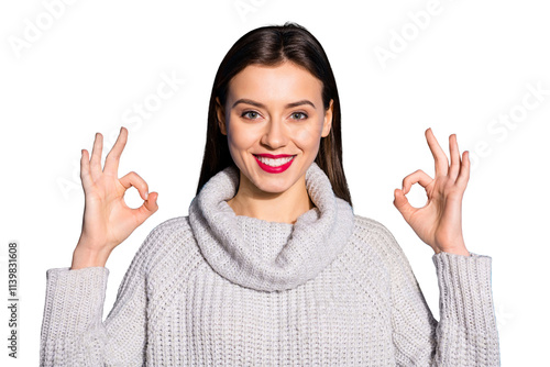 Portrait of charming millennial showing promo smiling at camera wearing gray jumper isolated over blue background photo