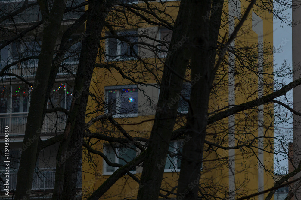 Obraz premium A vibrant yellow building stands prominently with lush green trees situated gracefully in front of it, creating a beautiful scene